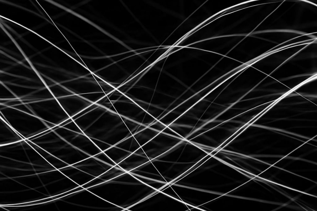 Abstract black and white light trails forming a complex, interconnected network web defining how to bring separate ideas together to create entity clarity.
